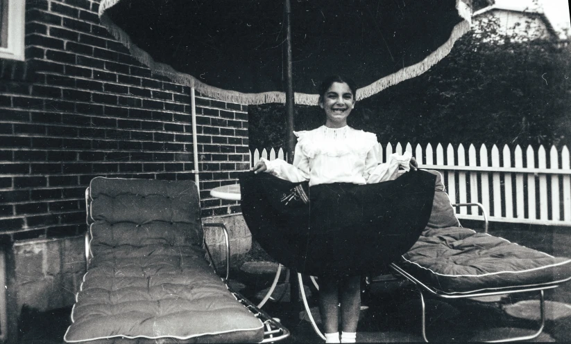 an old black and white po shows a woman holding an umbrella