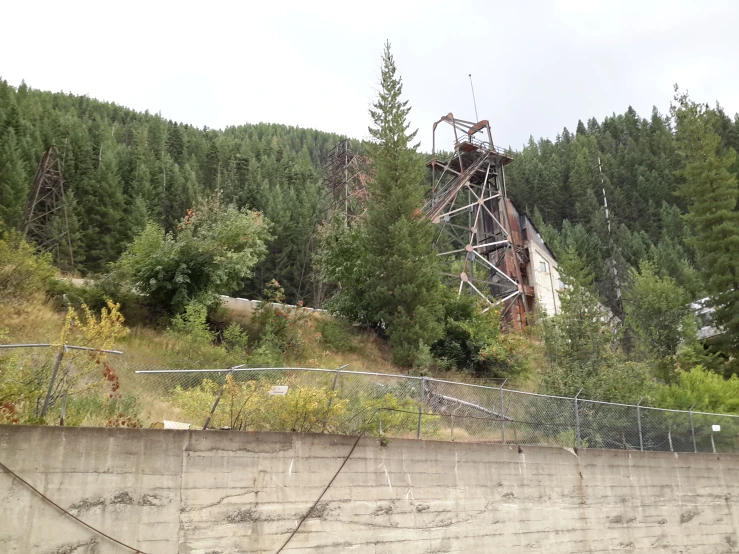 the rusted train trestle on the side of a road