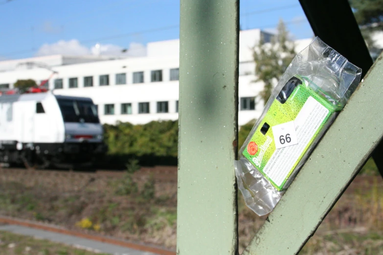 an iphone phone covered in plastic wrap on a railing