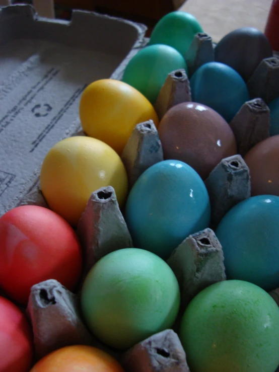 eggs are stacked in an egg carton with colored dye