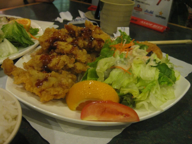 the plate is filled with salad, chicken and some vegetables