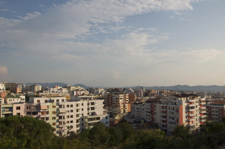 buildings with trees are surrounded by mountain ranges