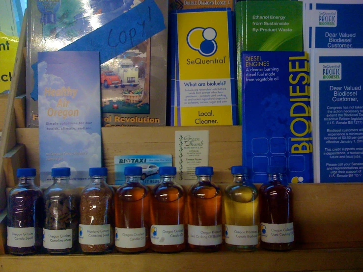 bottles of tea sit on a shelf above an assortment of books