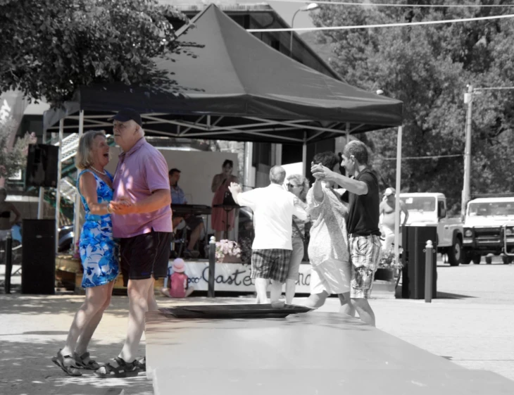 an older couple walk through a market place