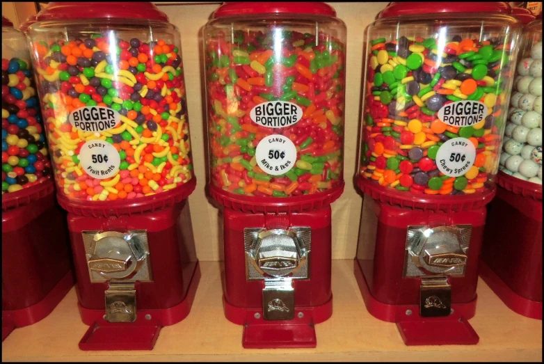 a row of gummy machine with different kinds of jelly