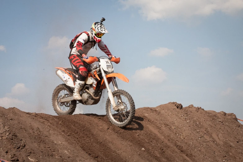 a man riding on the back of an orange dirt bike