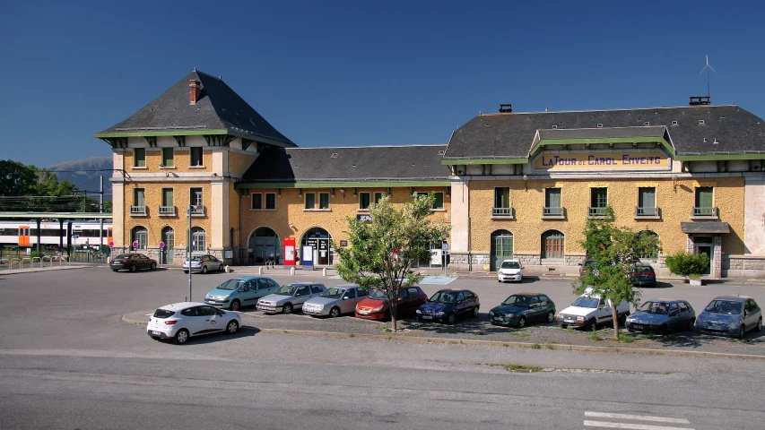 several cars parked in front of a building with two towers