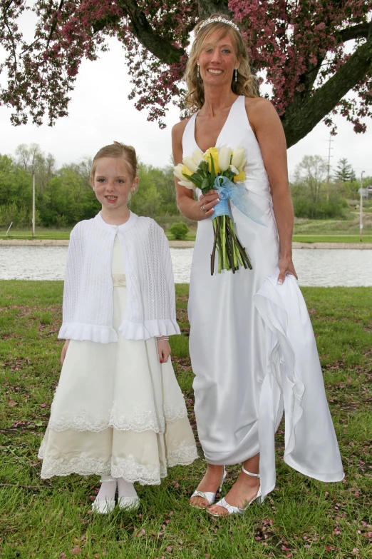 the woman and her daughter are wearing matching white dresses