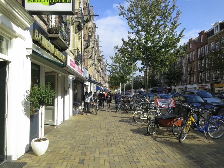 a city street filled with parked bicycles and people