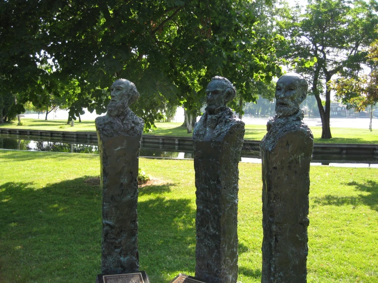 a collection of statues stand in the park