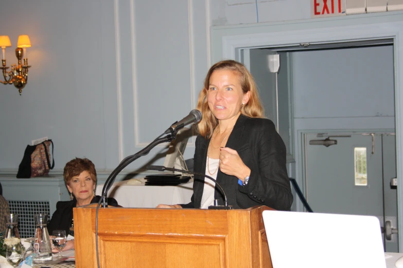 a woman standing behind a podium giving a speech