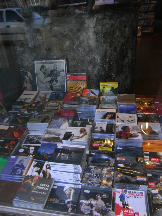 many cds are on a table next to a cell phone