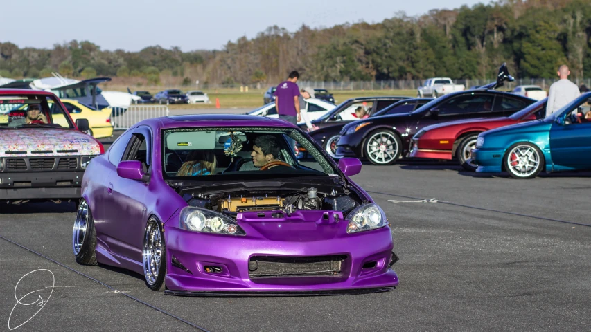 the purple car is parked next to other cars