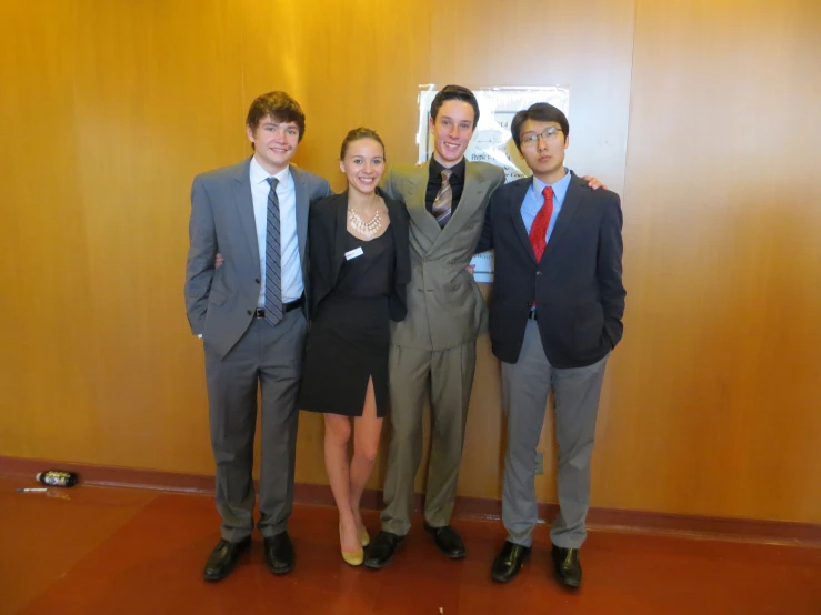 five people in business suits posing for a picture