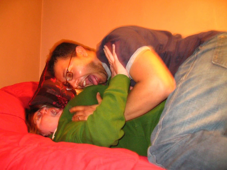 a woman is hugging a man in bed