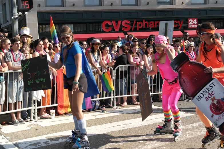 two people rollerblading on the road in front of an audience