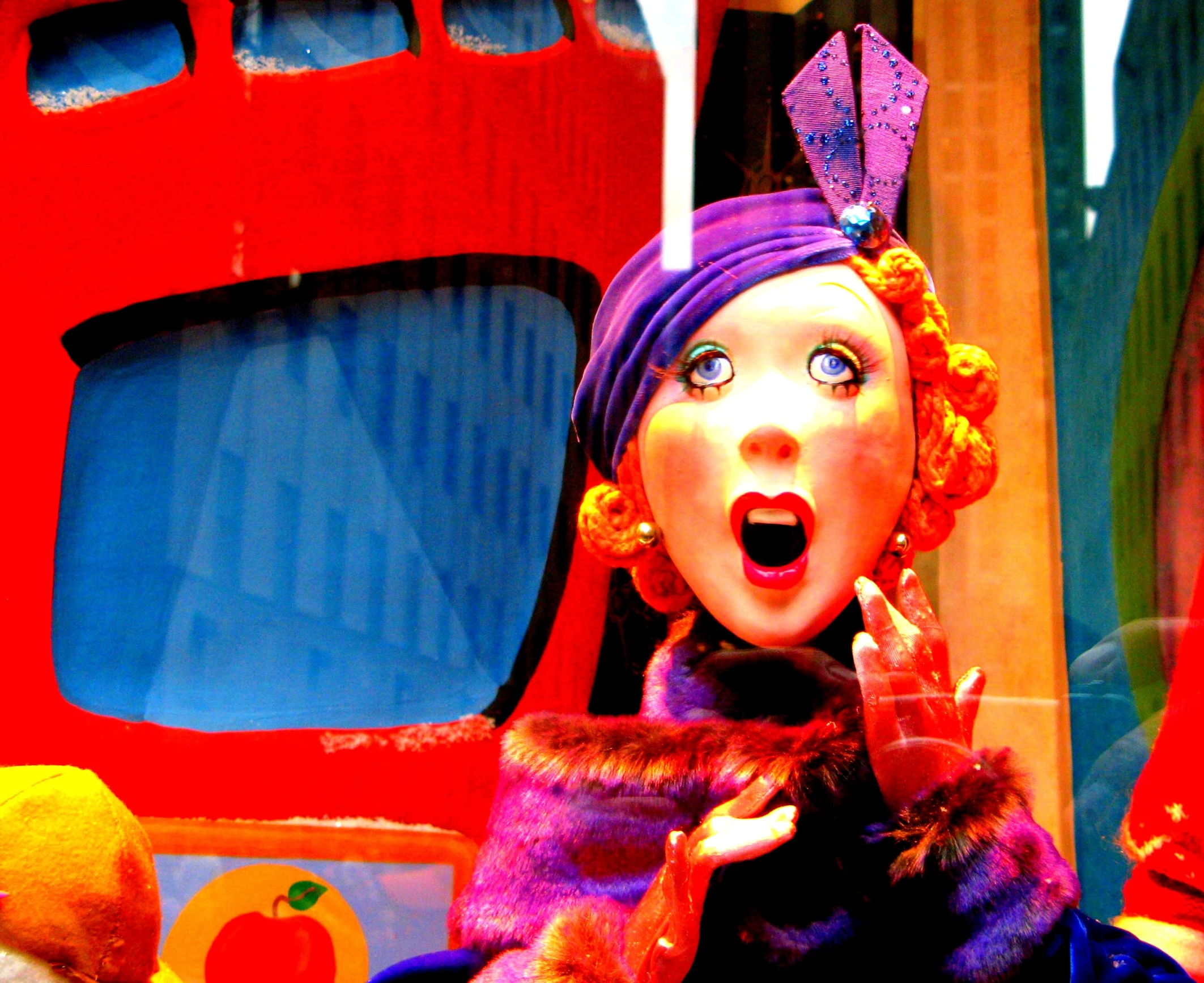 a woman with yellow hair and purple clothing is holding her head near a toy truck