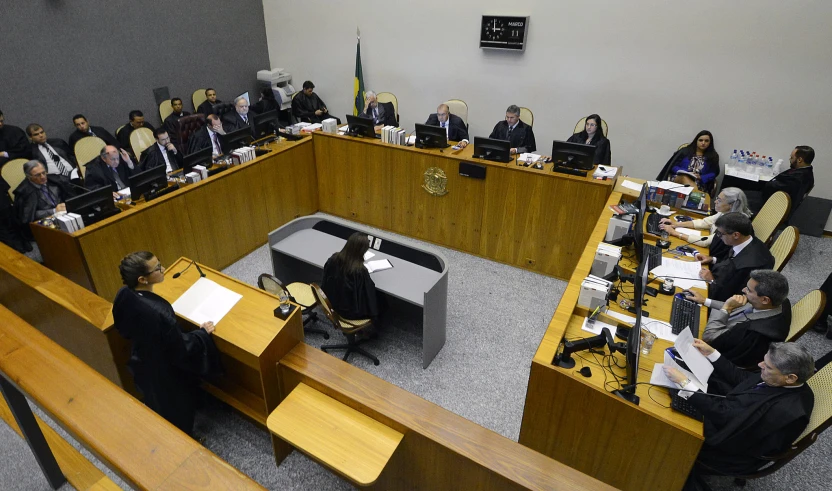 a group of people sitting at table in a courtroom