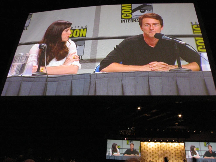 a man and woman sitting at a microphone