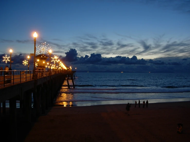 an evening view of a pier with christmas lights on it