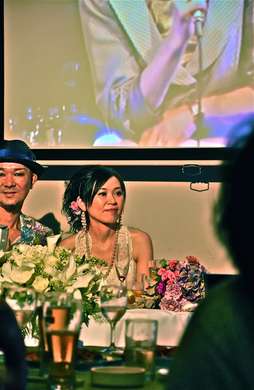 three people seated at a table in front of a projection