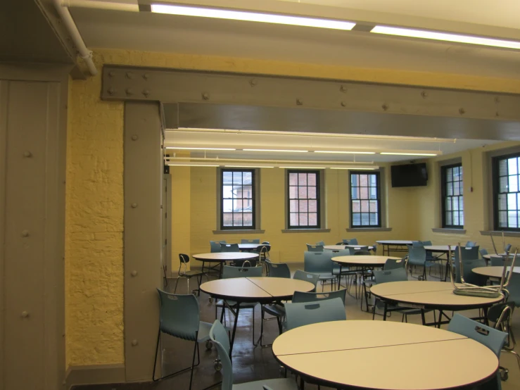 an empty classroom with chairs and tables in it