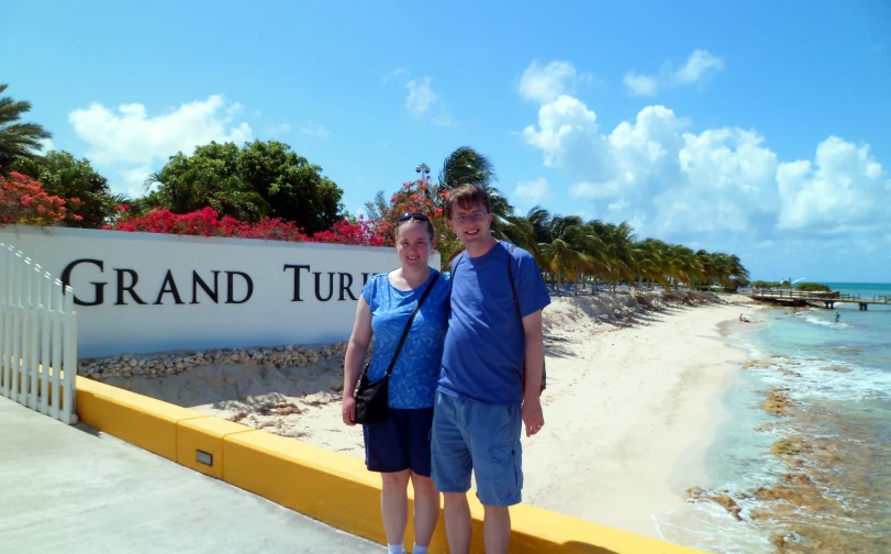 two people posing in front of the grand turki el sign