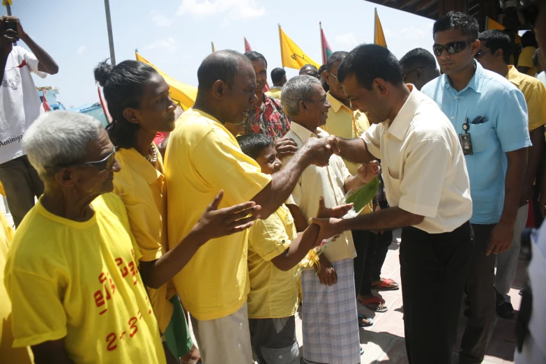 several people standing around each other shaking hands