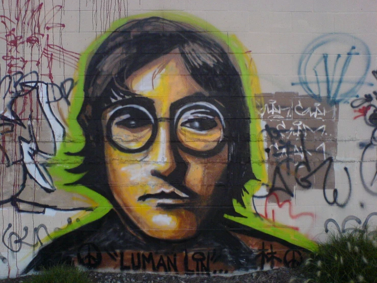 graffiti on the side of a building with the image of john lennon