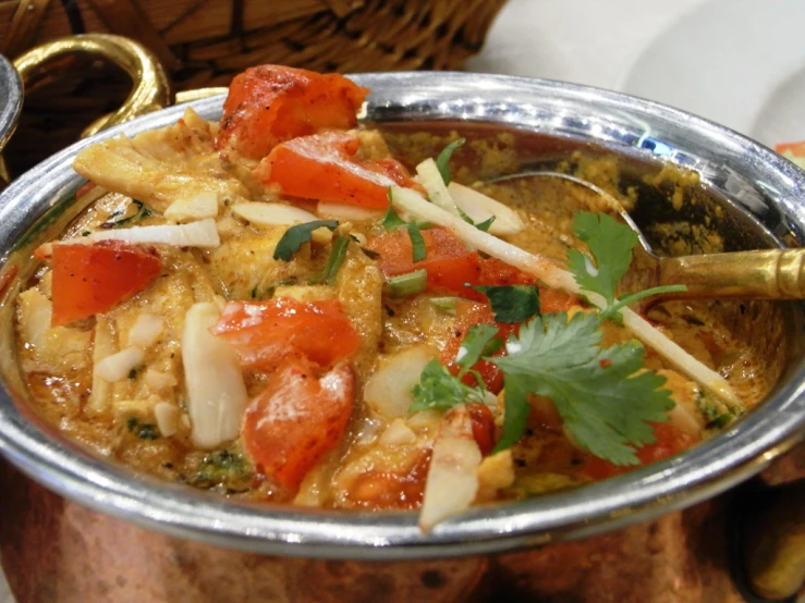 there is a silver bowl of food on a table