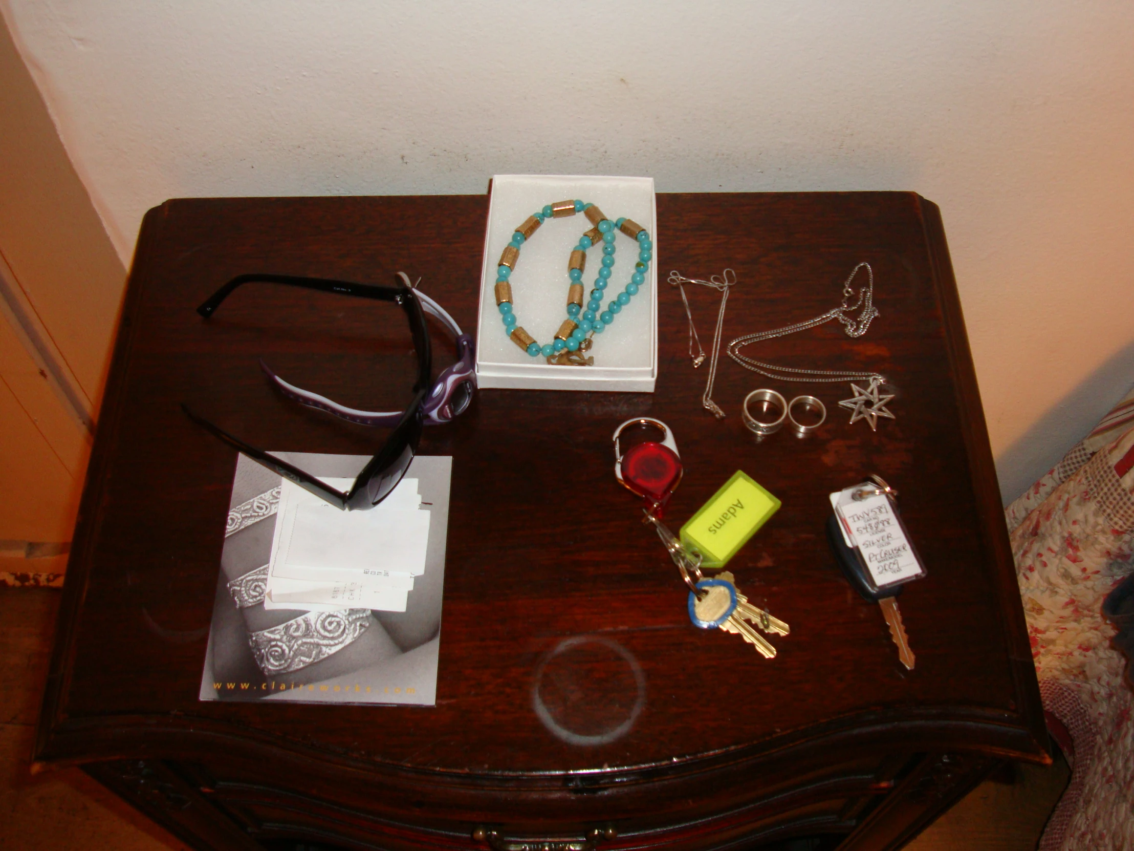 this wooden table is adorned with several jewelry items