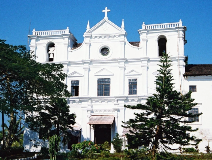 a big white building with towers and a cross at the top