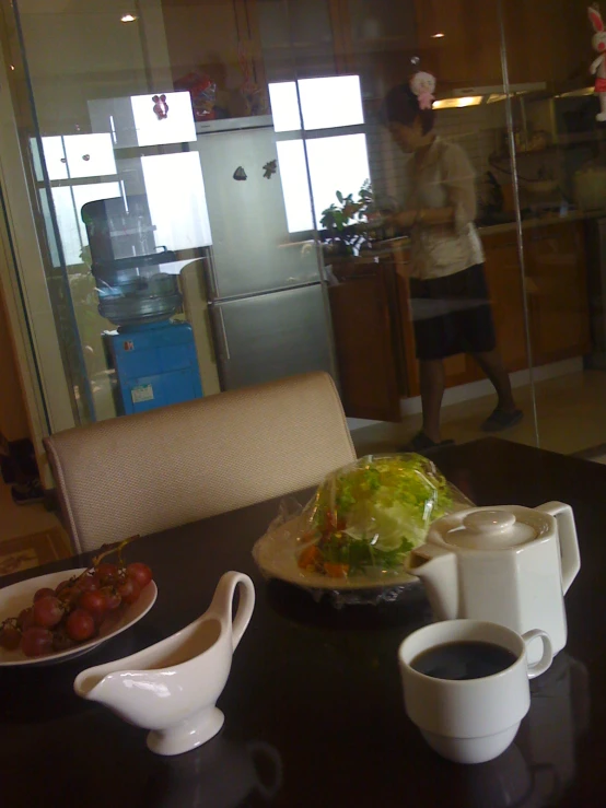 plates of food sit on a table in front of a woman and glass