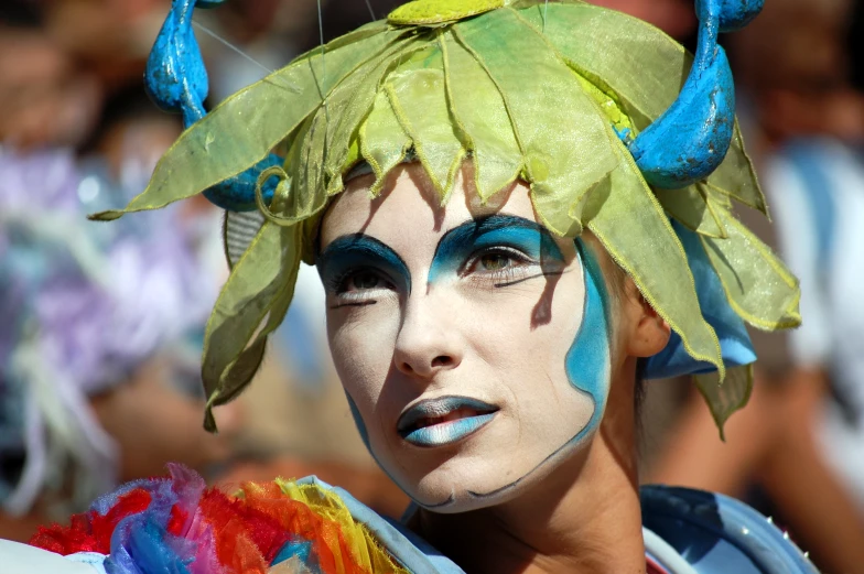 a man with a headpiece and green leaf on his face