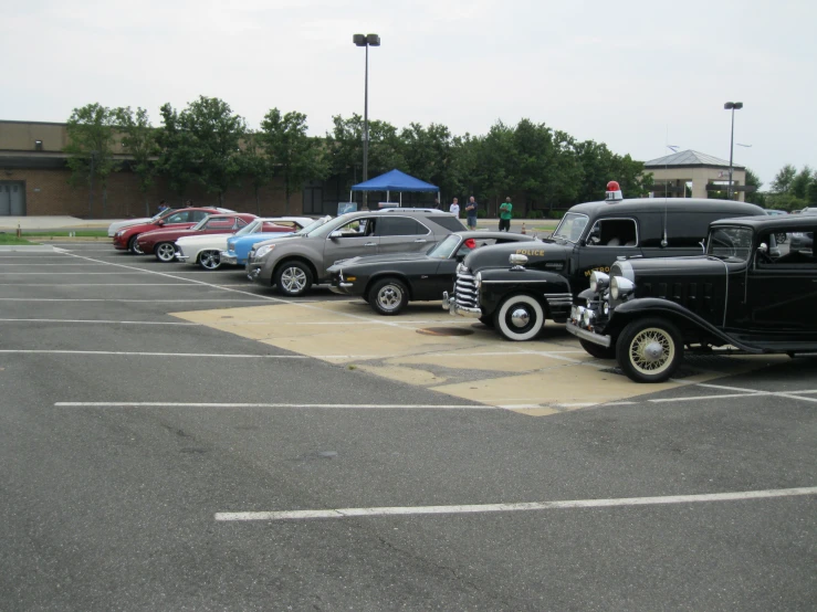 a row of vintage cars parked next to each other in a parking lot