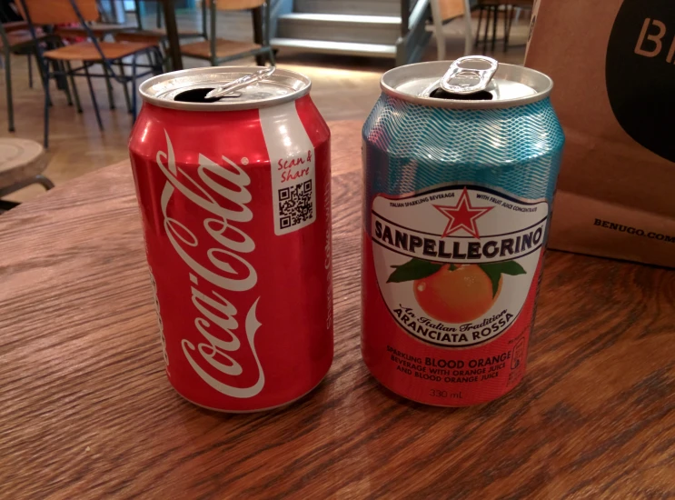 two cans of soda are sitting on a table