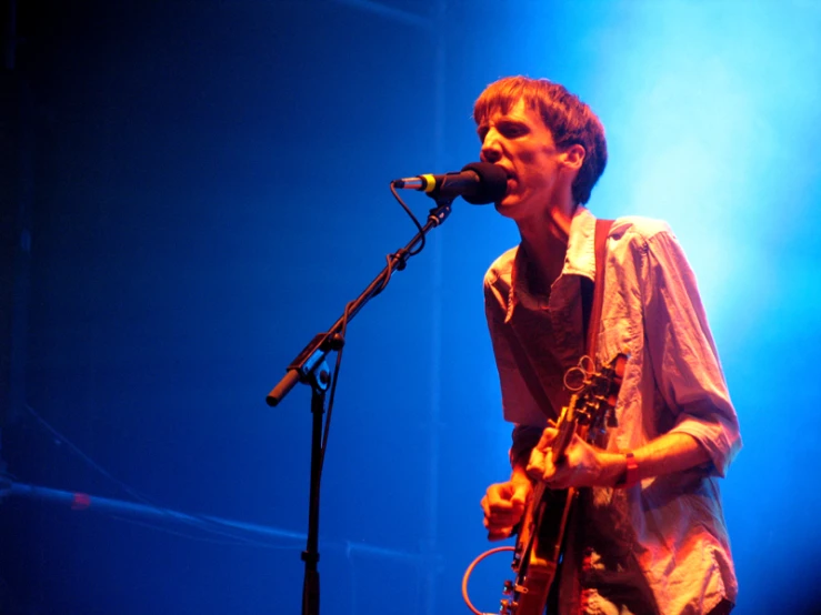 a man playing guitar at an event on stage