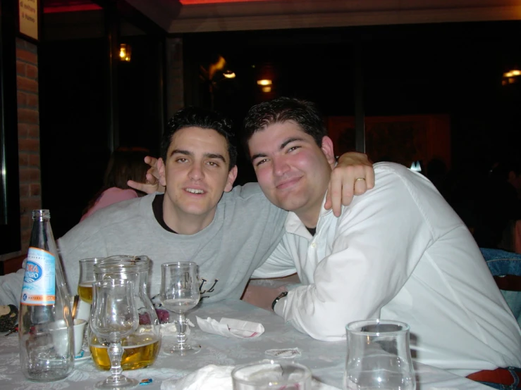 two men are smiling at the camera while sitting down