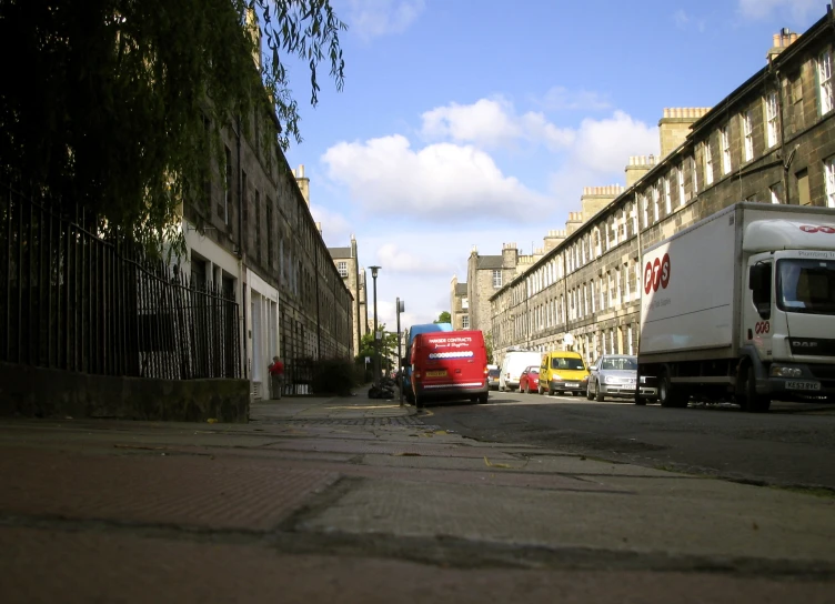 a red delivery truck drives down an old street