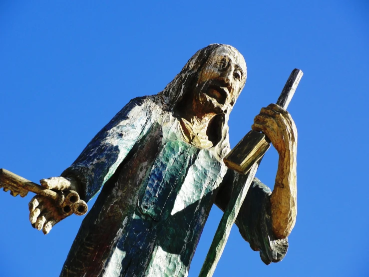 the statue is holding a sword on the blue sky