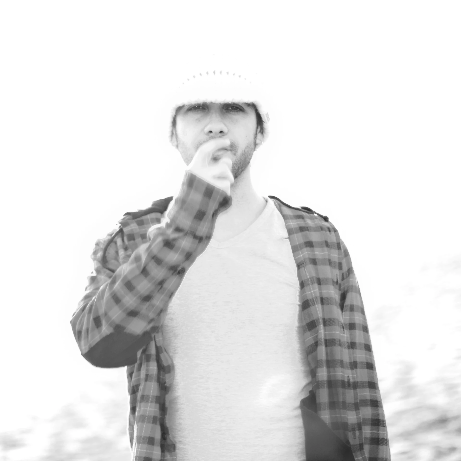 a man with a cap stands in front of a tree