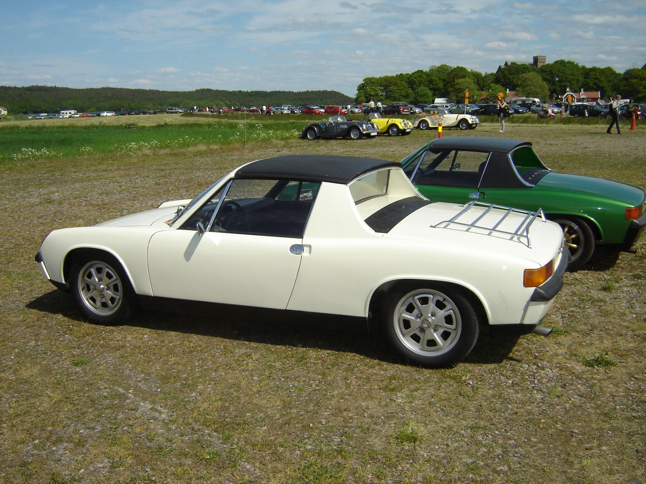 two cars parked in a field next to each other