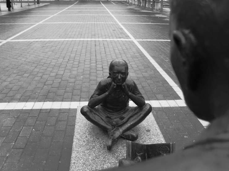 a man sitting on a bricked area in front of a building