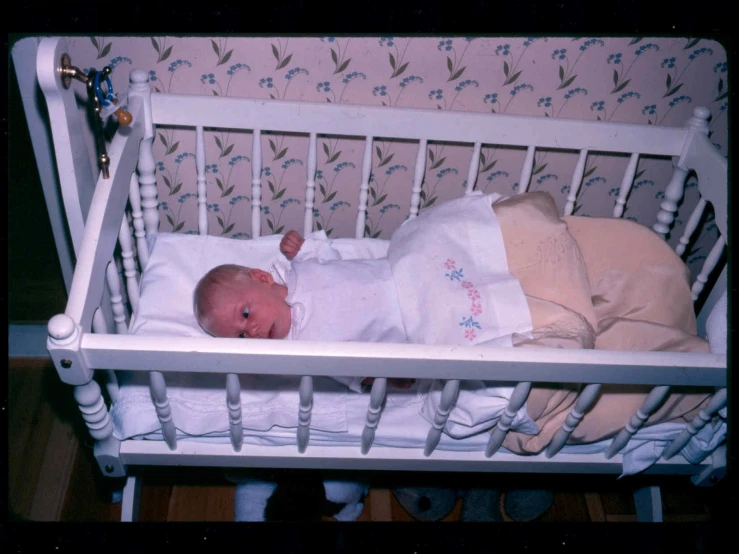 an infant sleeping in a crib while being dressed