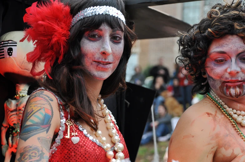two women are covered in white and red makeup