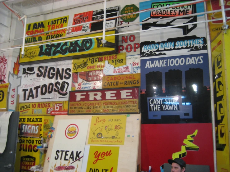 a wall covered with lots of signs and billboards