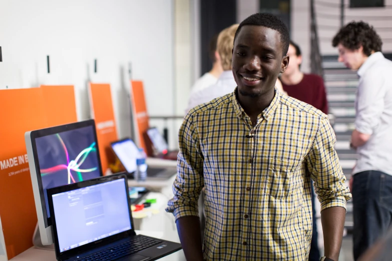 the man smiles while looking at his laptop