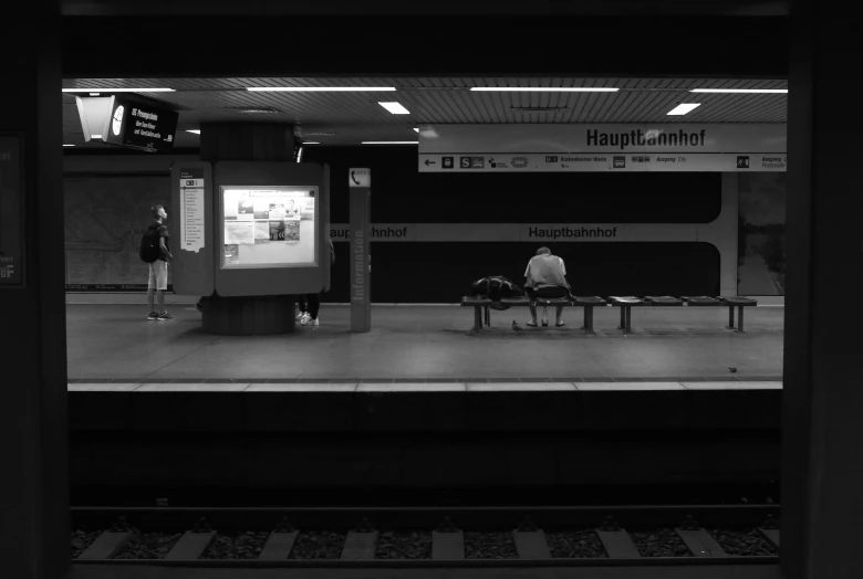 a train station with people waiting on the train