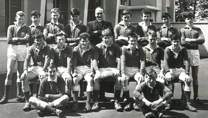 a group of young men sitting on top of a field