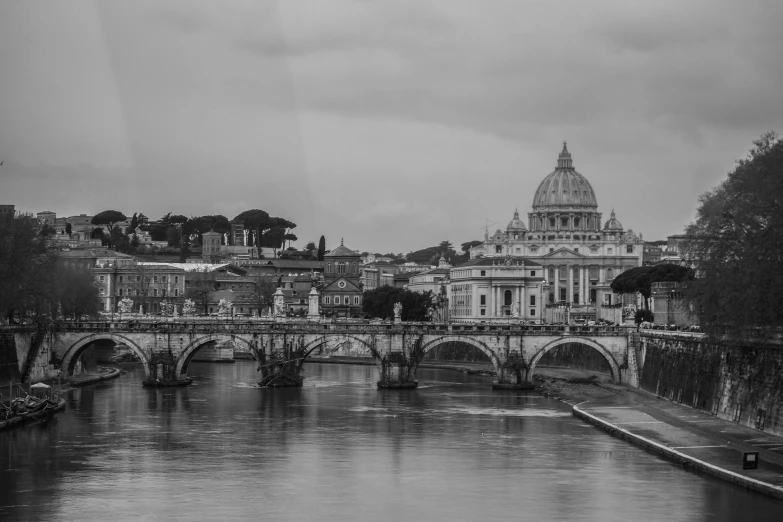 a river next to a bridge with an old building in the background